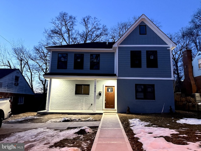 view of front of home featuring brick siding and a porch