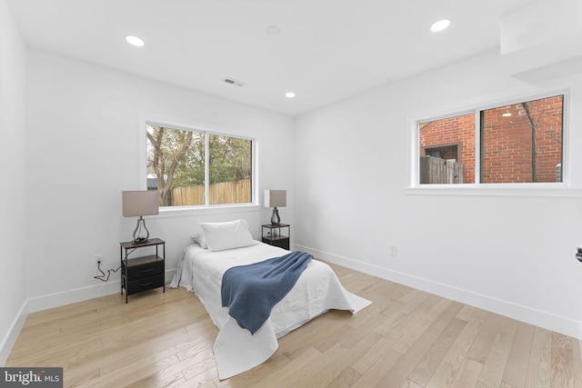 bedroom featuring light wood finished floors, recessed lighting, and baseboards