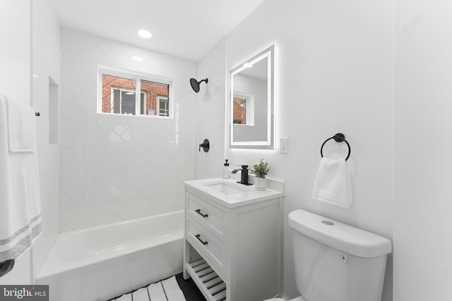 bathroom with washtub / shower combination, vanity, and toilet
