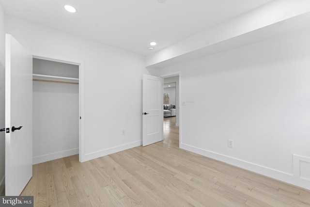 unfurnished bedroom featuring baseboards, a closet, recessed lighting, and light wood-style floors