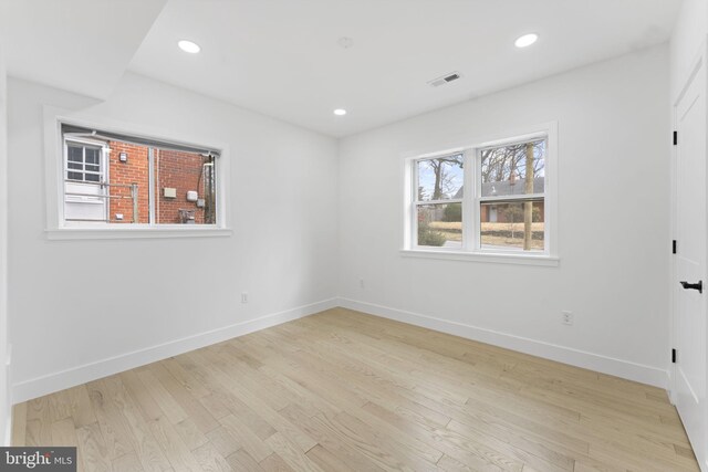 unfurnished room featuring light wood-style flooring, visible vents, baseboards, and recessed lighting