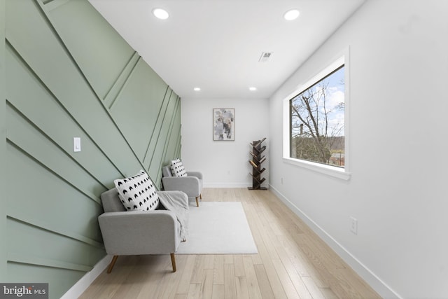 sitting room featuring baseboards, light wood-type flooring, visible vents, and recessed lighting