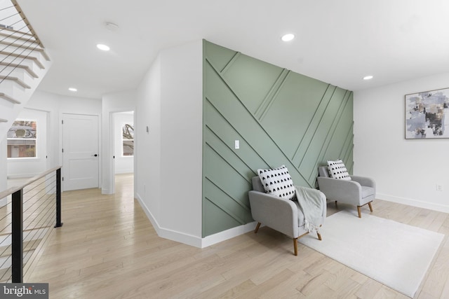 sitting room with baseboards, recessed lighting, stairs, and light wood-style floors