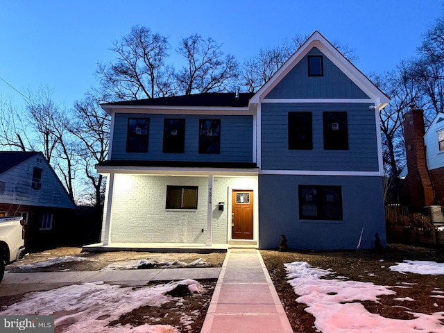 view of front of home featuring a porch and brick siding