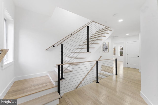 stairway with recessed lighting, wood finished floors, and baseboards