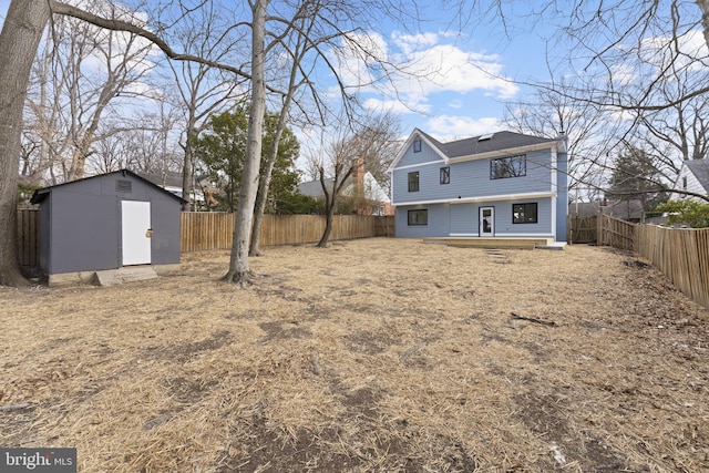 view of yard featuring an outbuilding, a fenced backyard, and a storage unit