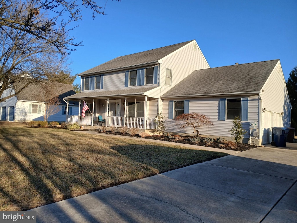 view of front facade with a porch, a garage, and a front lawn