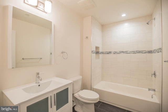 full bathroom featuring vanity, toilet, tiled shower / bath combo, and tile patterned flooring