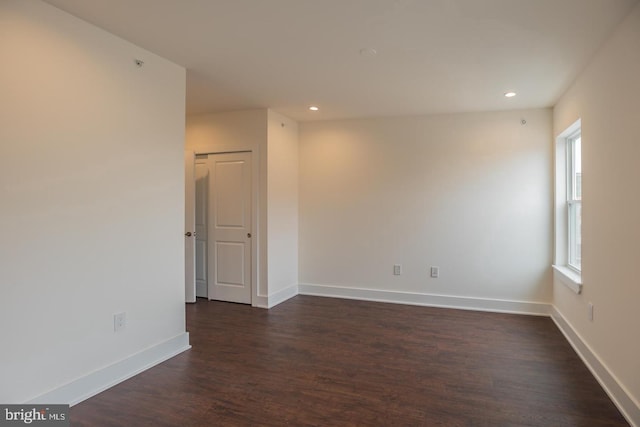 unfurnished room with dark wood-type flooring