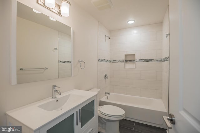 full bathroom with vanity, tiled shower / bath, tile patterned flooring, and toilet