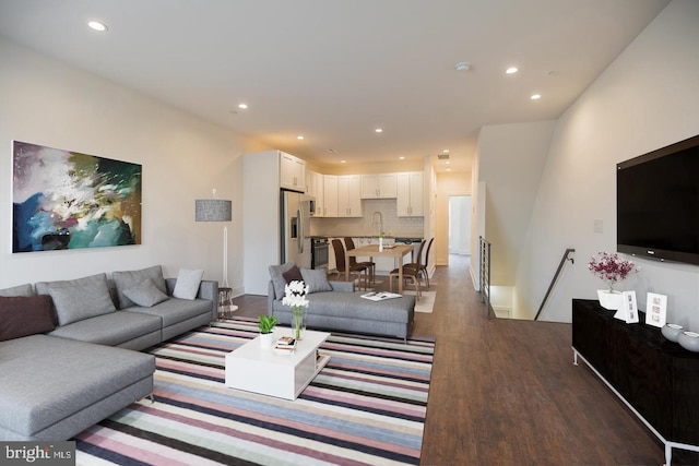 living room featuring dark wood-type flooring and sink