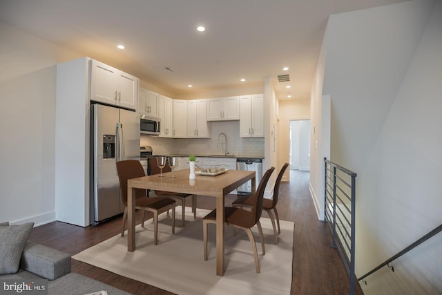 dining room with dark hardwood / wood-style floors and sink