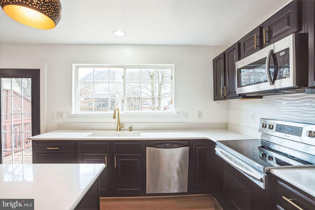 kitchen with dark brown cabinetry, sink, and appliances with stainless steel finishes