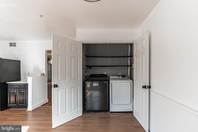 laundry room with washer and dryer and light wood-type flooring