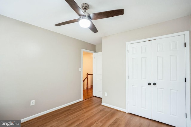 unfurnished bedroom with ceiling fan, light hardwood / wood-style floors, and a closet