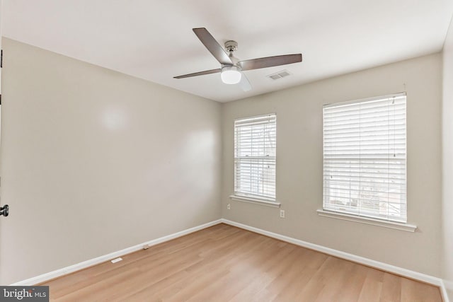 empty room with ceiling fan and light hardwood / wood-style flooring