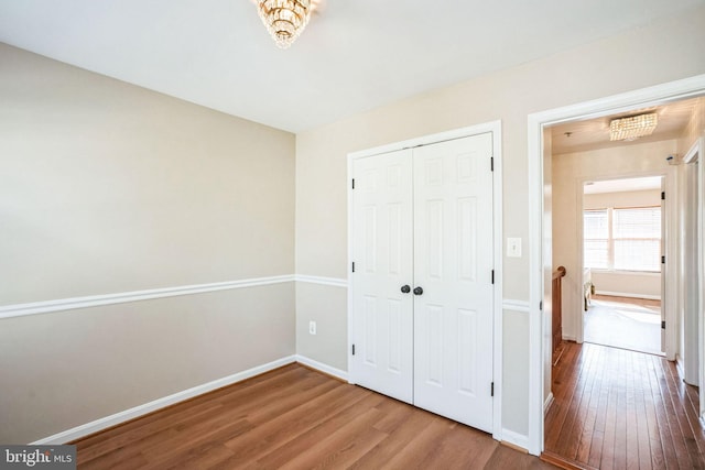 unfurnished bedroom with wood-type flooring and a closet