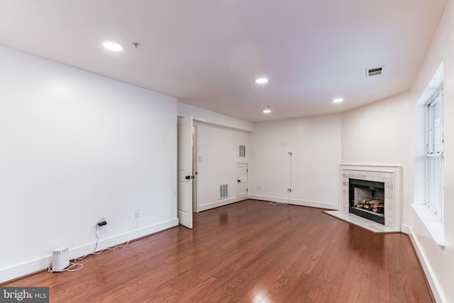 unfurnished living room featuring a premium fireplace and hardwood / wood-style floors