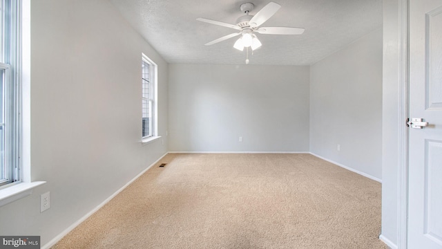 carpeted empty room featuring ceiling fan and a textured ceiling