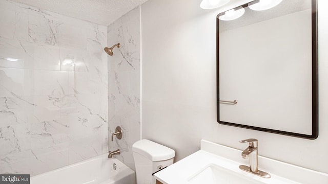 full bathroom featuring vanity, toilet, a textured ceiling, and tiled shower / bath