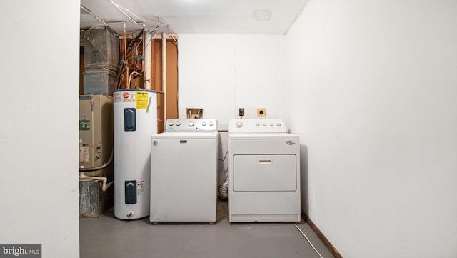 clothes washing area featuring separate washer and dryer and electric water heater