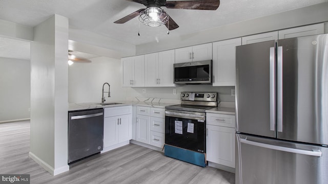 kitchen featuring white cabinetry, appliances with stainless steel finishes, sink, and light hardwood / wood-style flooring