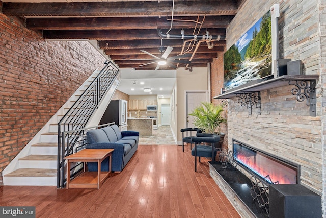 living room with a fireplace, wood-type flooring, and a high ceiling