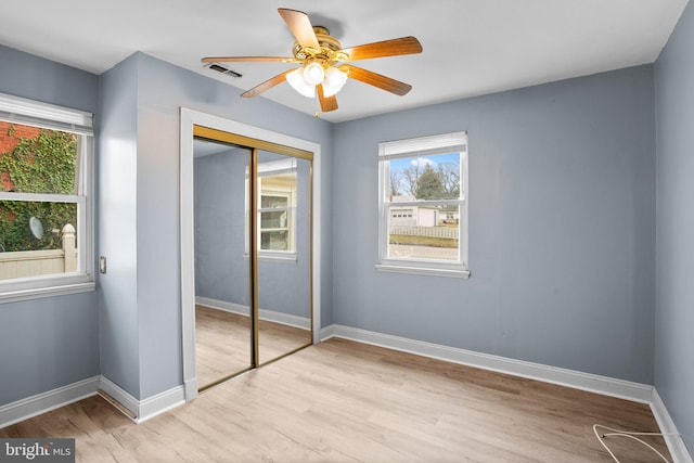 unfurnished bedroom with visible vents, a closet, light wood-style flooring, and baseboards