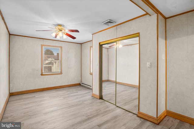 unfurnished bedroom with crown molding, a baseboard radiator, a closet, visible vents, and wood finished floors