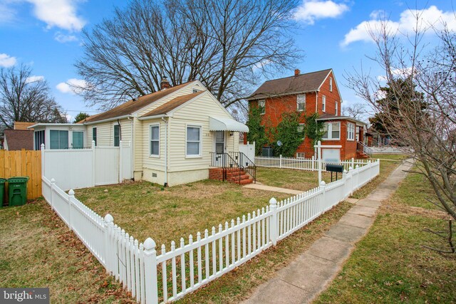 view of front of house featuring crawl space, a fenced front yard, and a front lawn