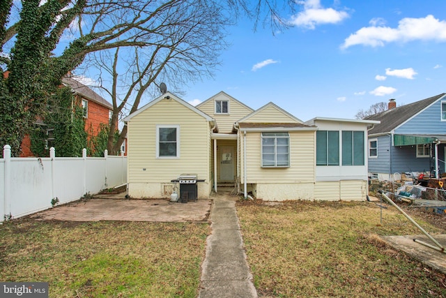 bungalow-style home featuring a patio, a front yard, and fence