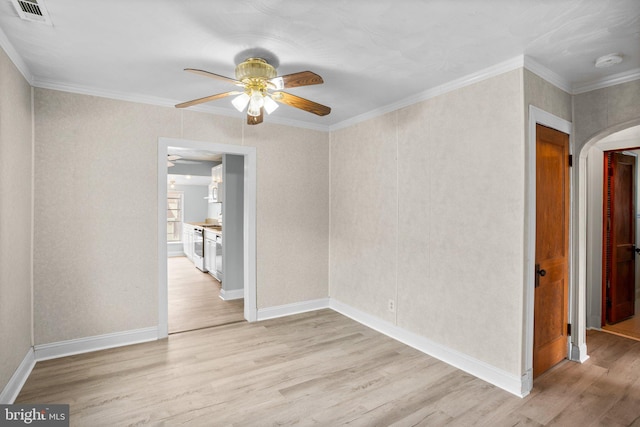 unfurnished room with visible vents, arched walkways, ceiling fan, crown molding, and light wood-style floors