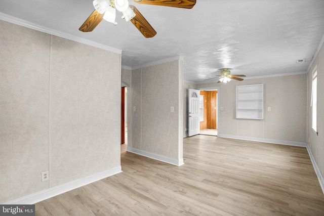 empty room featuring arched walkways, built in shelves, light wood-style flooring, a ceiling fan, and ornamental molding