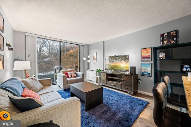 living room featuring hardwood / wood-style flooring, floor to ceiling windows, and a textured ceiling