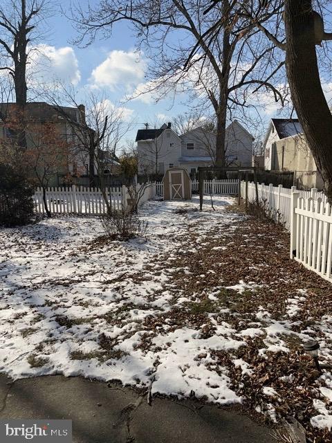 yard covered in snow with a storage shed