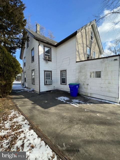 snow covered rear of property with cooling unit