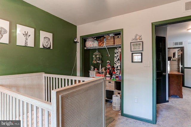 bedroom featuring light colored carpet and a closet