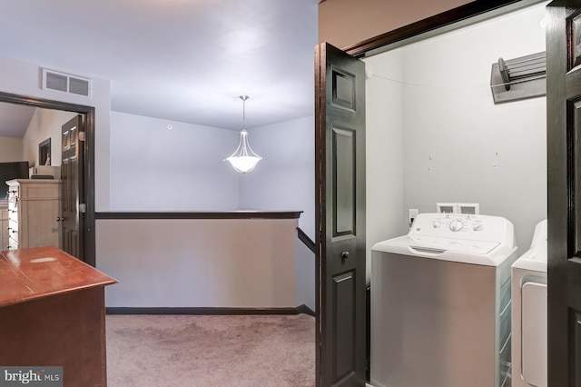 washroom with washer and clothes dryer and light colored carpet