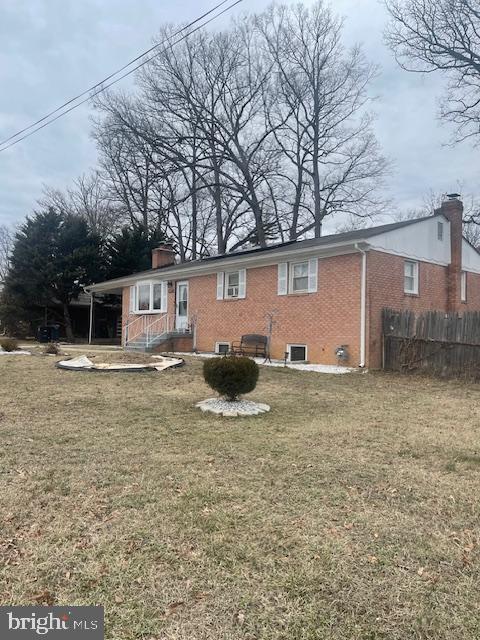 rear view of house featuring a yard