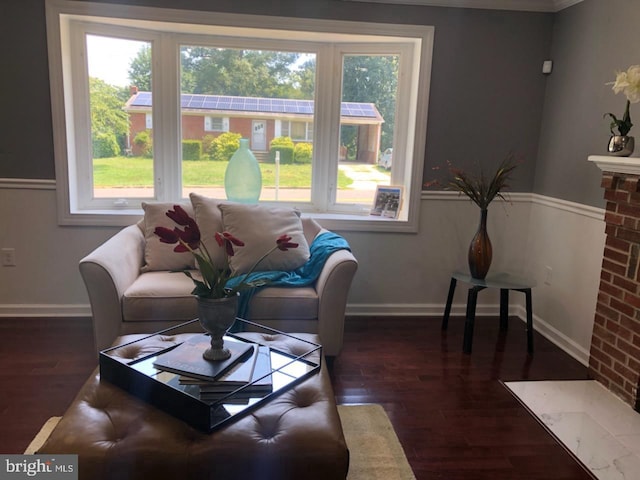 living room with plenty of natural light, dark hardwood / wood-style flooring, and a brick fireplace