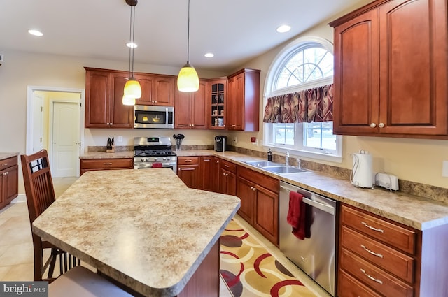 kitchen featuring a breakfast bar, sink, hanging light fixtures, a center island, and stainless steel appliances