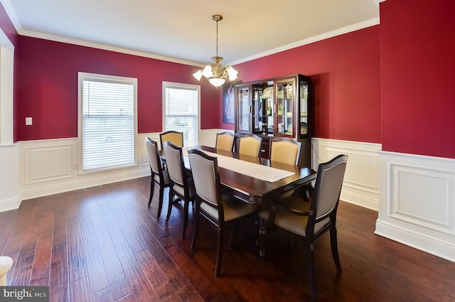 dining space featuring an inviting chandelier, dark hardwood / wood-style flooring, and ornamental molding