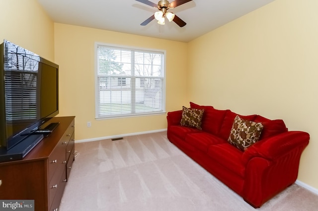 carpeted living room with ceiling fan