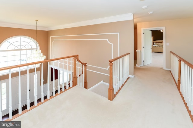 hallway featuring light carpet, crown molding, and an inviting chandelier