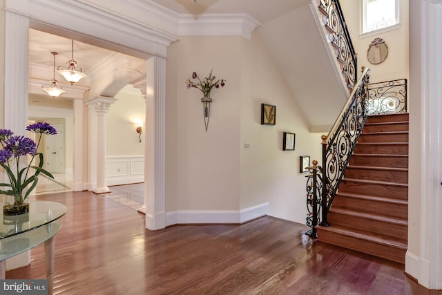 foyer with hardwood / wood-style flooring, ornamental molding, and decorative columns