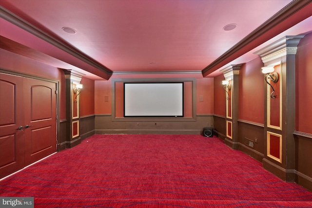 home theater room with ornate columns, carpet, and crown molding