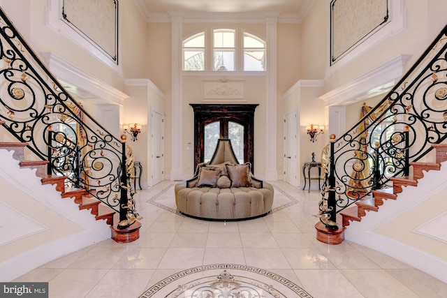 entryway with crown molding, tile patterned floors, and a high ceiling