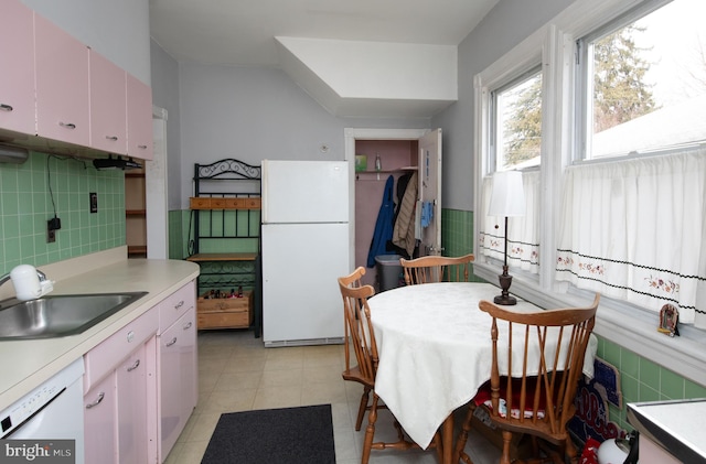 kitchen featuring white appliances, sink, and backsplash