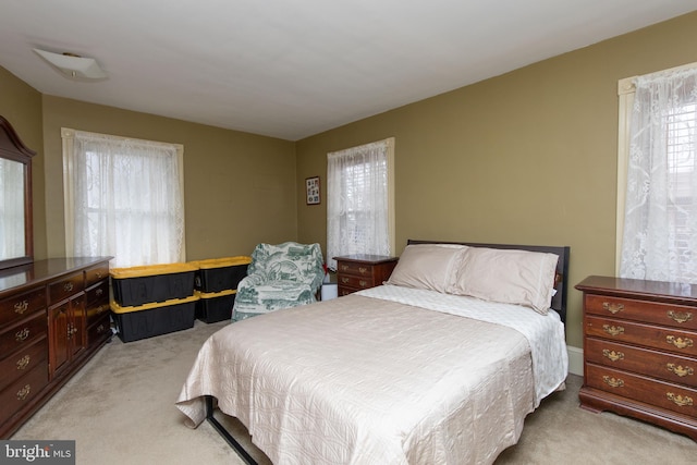 bedroom featuring multiple windows and light carpet