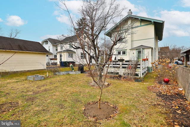 rear view of house featuring a yard and a deck